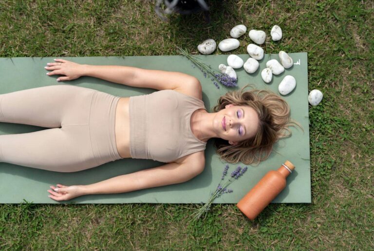 Marie Honeycutt in savasana ending her morning stretches routine on a sage green yoga mat